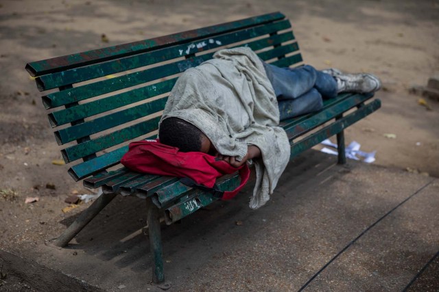 Fotografía del 3 de marzo de 2018 de un adolescente durmiendo en una silla en una plaza en Caracas (Venezuela). La inédita crisis económica y social de Venezuela se hace inocultable en calles y casas de abrigo que a diario reciben a niños que han quedado desamparados después de que sus padres emigraran a otro país a buscar nuevas formas de ingresos y los dejaran a cargo de personas que no pueden mantenerlos. EFE/MIGUEL GUTIÉRREZ