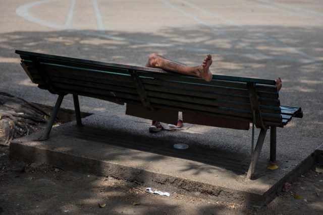 Fotografía del 3 de marzo de 2018 de un adolescente durmiendo en una silla en una plaza en Caracas (Venezuela). La inédita crisis económica y social de Venezuela se hace inocultable en calles y casas de abrigo que a diario reciben a niños que han quedado desamparados después de que sus padres emigraran a otro país a buscar nuevas formas de ingresos y los dejaran a cargo de personas que no pueden mantenerlos. EFE/MIGUEL GUTIÉRREZ