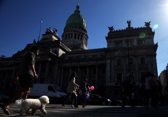 People cross the street outside the Congress in Buenos Aires, Argentina, March 6, 2018. REUTERS/Marcos Brindicci