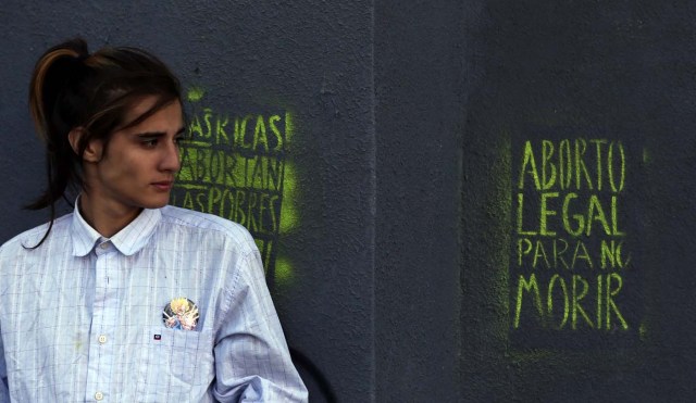 A man stands next to a grafitti that reads "Legal abortion to not die" outside the Congress in Buenos Aires, Argentina, March 6, 2018. REUTERS/Marcos Brindicci