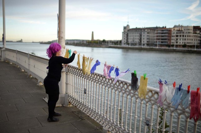 A protester hangs gloves with messages while taking part in a strike for women's rights in Portugalete, Spain, March 8, 2018, on International Women's Day. REUTERS/Vincent West