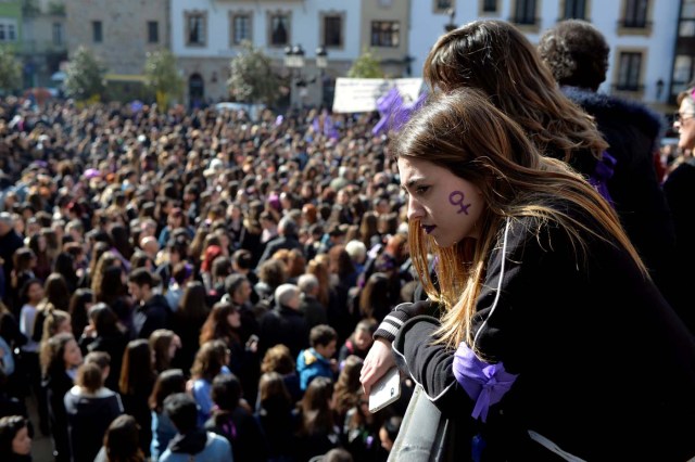 A woman with a female gender symbol on her cheek observes a demonstration for women's rights in Bilbao, Spain, March 8, 2018, on International Women's Day. REUTERS/Vincent West