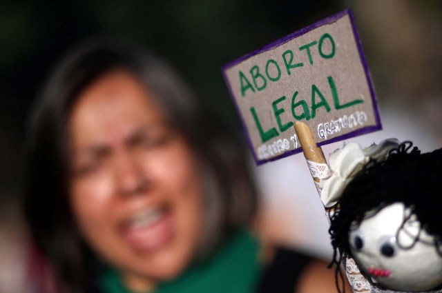 A woman shouts slogans next to a sign that reads "Legal abortion" during a demonstration on International Women's Day in Buenos Aires, Argentina, March 8, 2018. REUTERS/Marcos Brindicci