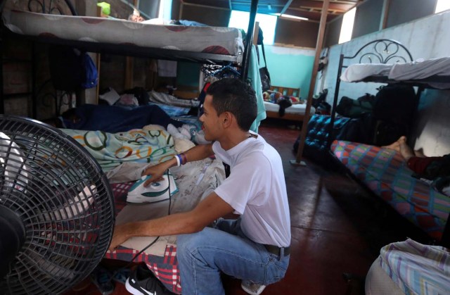 A Venezuelan migrant irons clothes to go to work, at a shelter for Venezuelans in San Juan de Lurigancho, on the outskirts of Lima, Peru March 9, 2018. REUTERS/Mariana Bazo