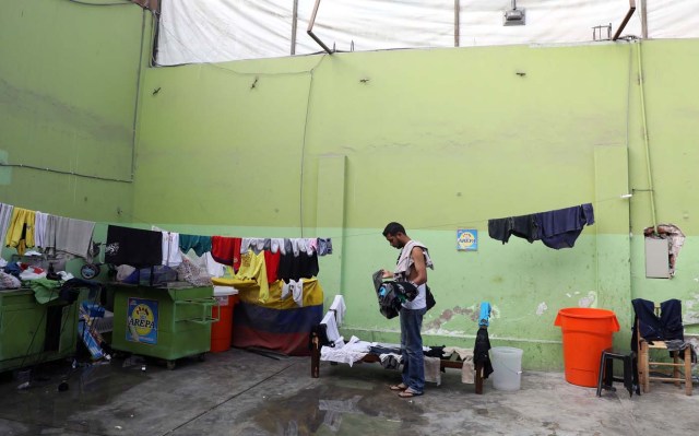 A Venezuelan migrant hangs clothes in a shelter for Venezuelans in San Juan de Lurigancho, on the outskirts of Lima, Peru March 9, 2018. REUTERS/Mariana Bazo