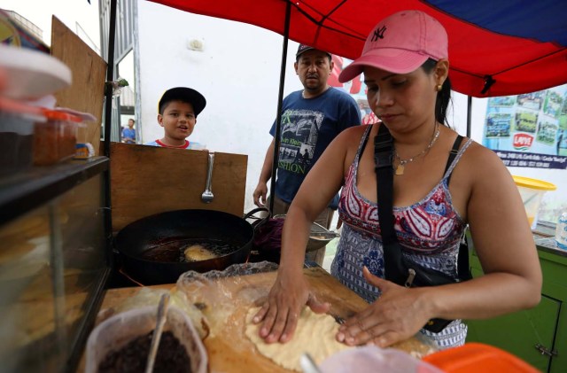 A Venezuelan migrant prepares food for sale outside a shelter for Venezuelans in San Juan de Lurigancho, on the outskirts of Lima, Peru March 9, 2018. REUTERS/Mariana Bazo