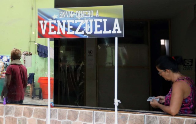 A Venezuelan migrant stands next to a sign reading: ' Send money to Venezuela' at a shelter for Venezuelans in San Juan de Lurigancho, on the outskirts of Lima, Peru March 9, 2018. REUTERS/Mariana Bazo