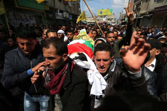 ATTENTION EDITORS - VISUAL COVERAGE OF SCENES OF INJURY OR DEATH Mourners carry the body of Palestinian farmer Omar Samour who was killed along Israel border with Gaza, during his funeral in the southern Gaza Strip March 30, 2018. REUTERS/Ibraheem Abu Mustafa