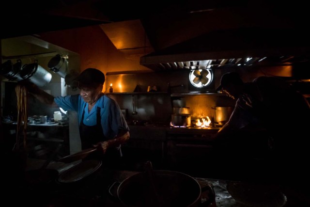 CAR207. CARACAS (VENEZUELA), 05/03/2018.- Un cocinero trabaja a oscuras en un restaurante durante una falla eléctrica hoy, lunes 5 de marzo de 2018, en Caracas (Venezuela). Un fallo eléctrico del que se desconocen por ahora los detalles ha dejado sin luz a la capital venezolana, Caracas, por tercera vez en tres meses, y 10 días después de otro apagón que afectó a una decena de estados del país petrolero. EFE/MIGUEL GUTIÉRREZ