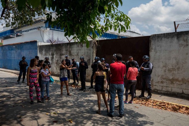 VALENCIA (VENEZUELA), 28/03/2018.- Un grupo de familiares de presos hablan con miembros de la Policía hoy, miércoles 28 de marzo de 2018, en las inmediaciones del centro de reclusión de la Policía Estatal de Carabobo (centro) en Valencia (Venezuela). Un motín en el centro de reclusión de la Policía Estatal de Carabobo dejó hoy cinco reclusos muertos y dos policías heridos, según informaron medios locales. EFE/Miguel Gutiérrez