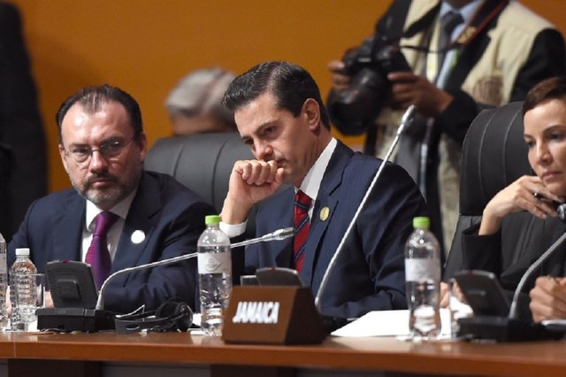 Mexican President Enrique Pena Nieto (C) attends the plenary session of the Eighth Americas Summit in Lima, on April 14, 2018. US strikes on Syria overshadowed the Americas Summit, which ends Saturday condemning corruption and calling for more sanctions on the Venezuelan government. / AFP PHOTO / Luka GONZALES