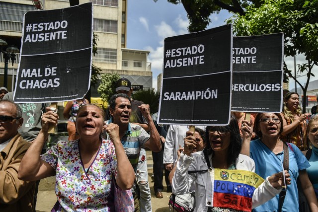 Health workers and patients protest for the lack of medicines, medical supplies and poor conditions in hospitals, in Caracas on April 17, 2018. Doctors and nurses protest against the health crisis in Venezuela, currently in the midst of a deep economic and political crisis and where health authorities have reported a rise in vaccine-preventable diseases. / AFP PHOTO / Luis ROBAYO