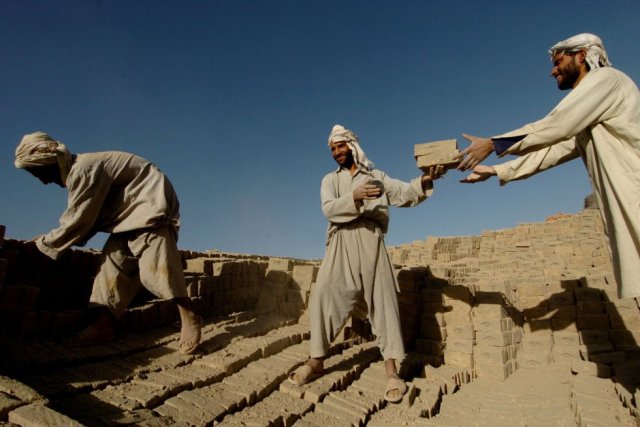 Trabajadores afganos descargan ladrillos en un horno en la ciudad de Kabul (Afganistán), el 24 de septiembre de 2007. SHAH MARAI AFP