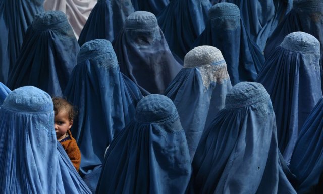 Una mujer afgana sostiene a su bebé en brazos mientras asiste a un mitin electoral del candidato presidencial afgano, Abdullah Abdullah, en Jalalabad, el 18 de febrero de 2014. SHAH MARAI AFP