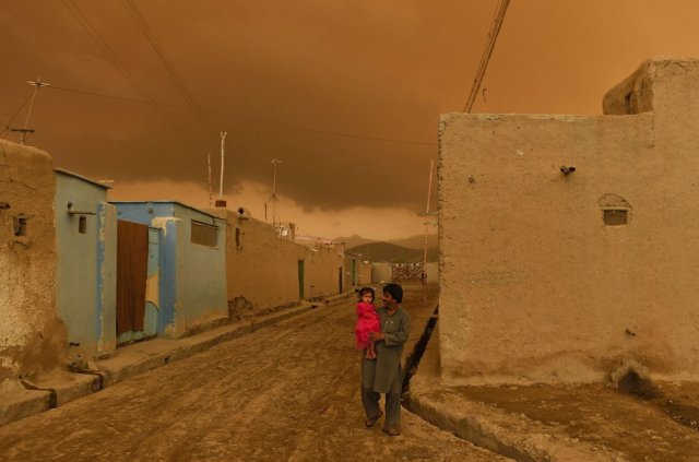 Un padre afgano carga a su hija momentos antes de una tormenta, el 19 de abril de 2015, en Kabul. SHAH MARAI AFP