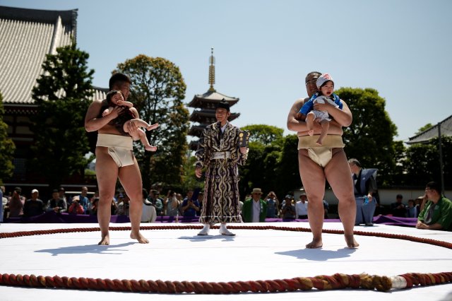 Babies cry as they are held up by amateur sumo wrestlers during a baby crying contest at Sensoji temple in Tokyo, Japan, April 28, 2018. In the contest two wrestlers each hold a baby while a referee makes faces and loud noises to make them cry. The baby who cries the loudest wins. The ritual is believed to aid the healthy growth of the children and ward off evil spirits. 160 children took part in the event in this year, the organiser said. REUTERS/Issei Kato