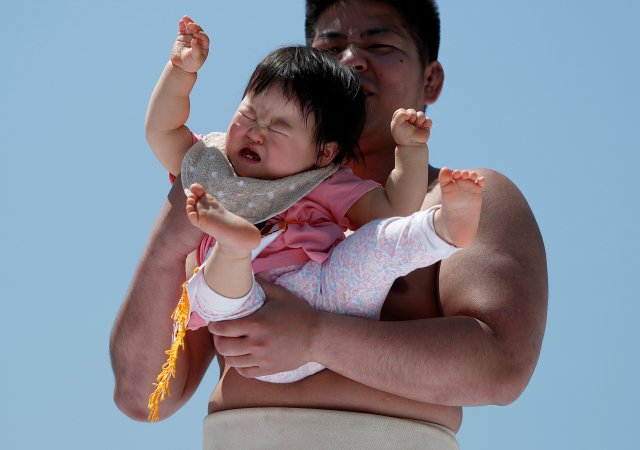 Un bebé llora en los brazos de un peleador de zumo amateur |FOTO: REUTERS/Issei Kato