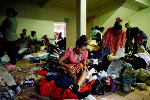 A woman holds a baby while staying at a shelter with fellow members of a caravan of migrants from Central America, prior to preparations for an asylum request in the U.S., in Tijuana, Mexico April 29, 2018. REUTERS/Edgard Garrido