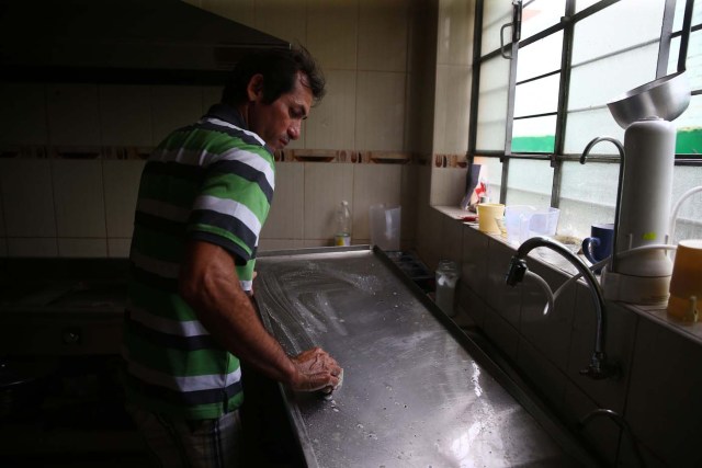 Acompaña crónica PERÚ VENEZUELA - PER12 - LIMA (PERÚ) , 26/4/2018.- Fotografía tomada el 25 de abril de 2018, de un inmigrante venezolano quien lava algunas utensilios de cocina en la vivienda donde temporalmente reside, en uno de los distritos mas populosos de la capital, San Juan de Lurigancho, en Lima (Perú). La solidaridad y caridad imperan en el improvisado albergue que un pequeño empresario peruano ha instalado para dar un primer techo a los venezolanos recién llegados a Lima, desde donde intentan comenzar una nueva vida a la que se vieron abocados por la crudeza de la crisis que atraviesa Venezuela. EFE / Ernesto Arias