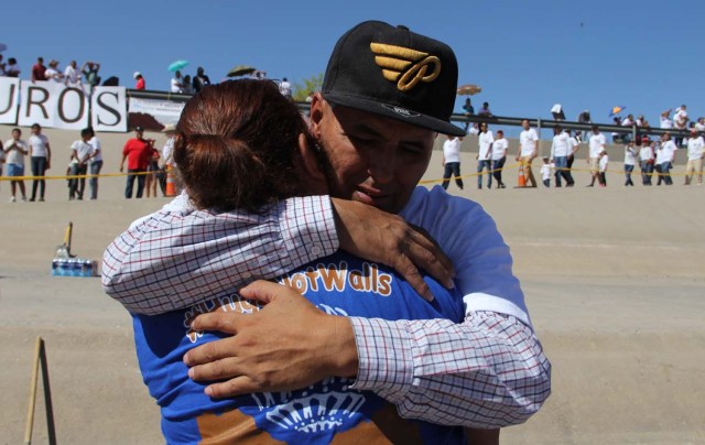 Mexican families living in US and Mexico embrace at the border line in the bank of Rio Grande to take part in the event called "Abrazos No Muros" (Hugs, not walls) promoted by the Border Network of Human Rights organization in the border line between El Paso, Texas, United States and Ciudad Juarez, Chihuahua state, Mexico on May 12, 2018. / AFP PHOTO / HERIKA MARTINEZ