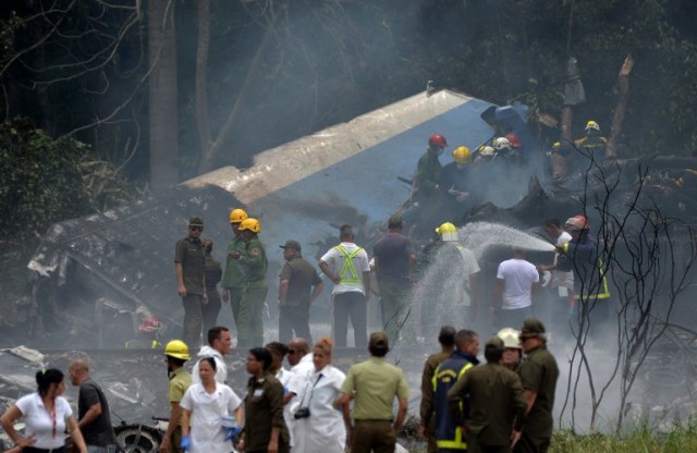 Emergency personnel work at the site of the accident after a Cubana de Aviacion aircraft crashed after taking off from Havana's Jose Marti airport on May 18, 2018. A Cuban state airways passenger plane with 113 people on board crashed on shortly after taking off from Havana's airport, state media reported. The Boeing 737 operated by Cubana de Aviacion crashed "near the international airport," state agency Prensa Latina reported. Airport sources said the jetliner was heading from the capital to the eastern city of Holguin. / AFP PHOTO / Yamil LAGE