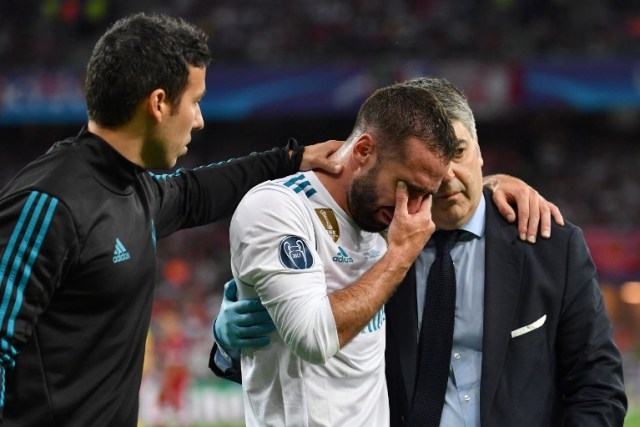 El defensa español del Real Madrid Dani Carvajal (C) reacciona cuando abandona el terreno de juego tras una lesión durante el partido de fútbol final de la UEFA Champions League entre el Liverpool y el Real Madrid en el Estadio Olímpico de Kiev, Ucrania, el 26 de mayo de 2018. / AFP PHOTO / GENYA SAVILOV