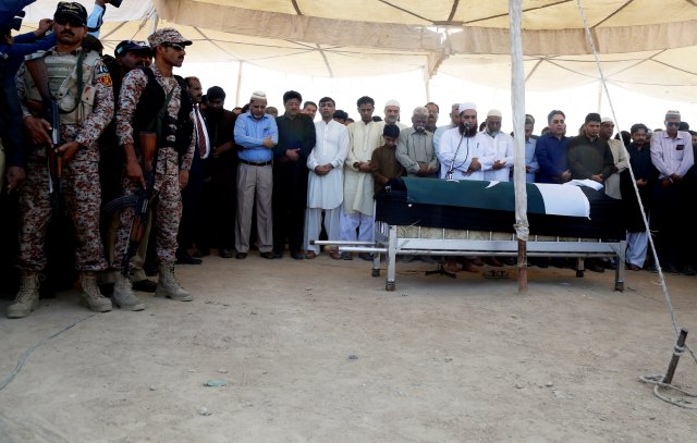 Paramilitary soldiers (L) stand guard as relatives and neighbours offer prayers for Sabika Aziz Sheikh, a Pakistani exchange student, who was killed with others when a gunman attacked Santa Fe High School in Santa Fe, Texas, U.S., during her funeral in Karachi, Pakistan May 23, 2018. REUTERS/Akhtar Soomro