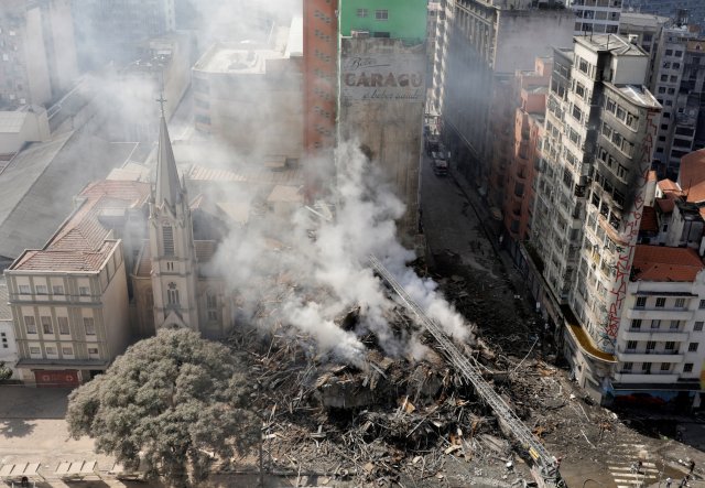 Firefighters try to extinguish a fire at a building in downtown Sao Paulo, Brazil May 1, 2018. REUTERS/Paulo Whitaker