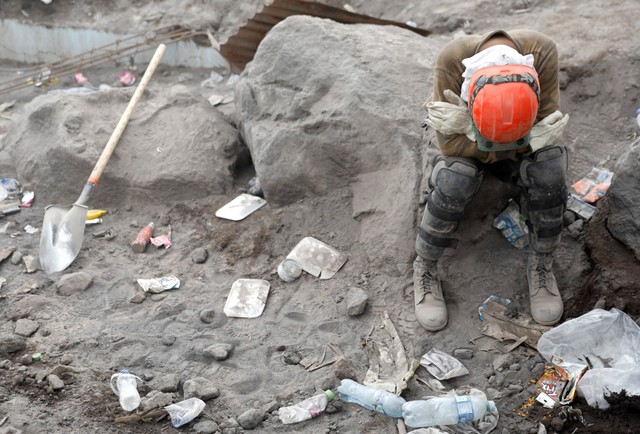 A rescue worker rests an area affected by the eruption of the Fuego volcano at San Miguel Los Lotes in Escuintla, Guatemala June 10, 2018. REUTERS/Carlos Jasso