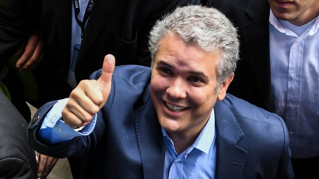 Colombian presidential candidate Ivan Duque, for the Democratic Centre party, gives his thumb up to supporters aftre voting at a polling station in Bogota during the first round of the presidential election in Colombia on May 27, 2018. Voters went to the polls Sunday to choose a new president of Colombia in a divisive election that is likely to weigh heavily on the future of the government's fragile peace deal with the former rebel movement FARC. / AFP PHOTO / Luis ACOSTA