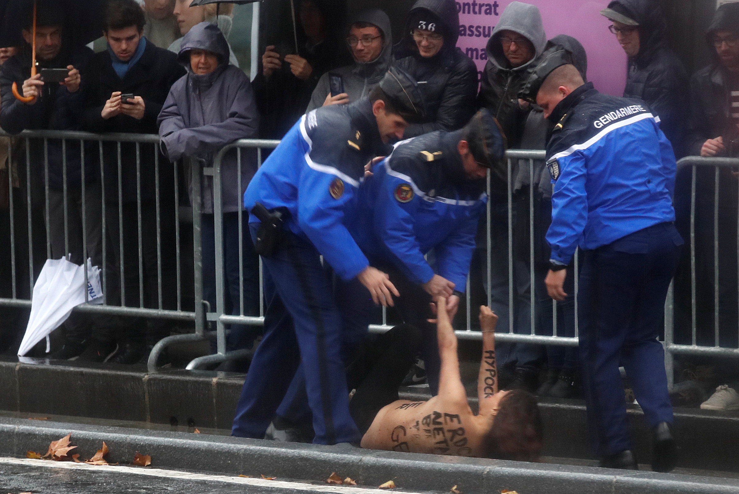 Manifestante en topless corre hacia convoy de Trump en París