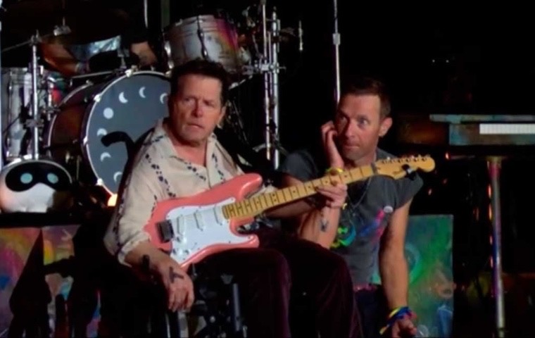 Coldplay sorprende a su público al tocar con Michael J. Fox en su concierto de Glastonbury