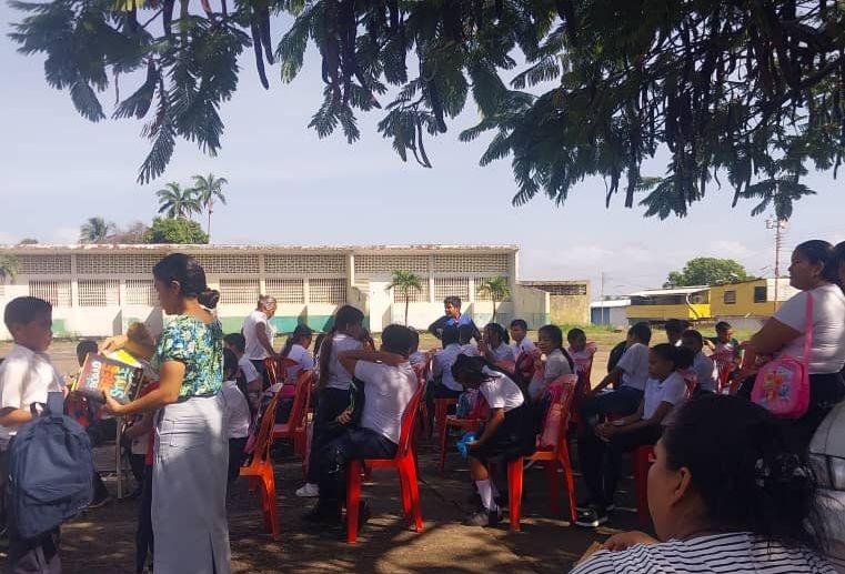 A la sombra de un árbol maestros corrigen tareas en una escuela de Ciudad Guayana